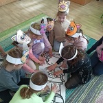 Grupka dziewczynek układa na dywanie duże puzzle.