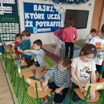 Przedszkolaki budują na krzesełkach wieże z klocków