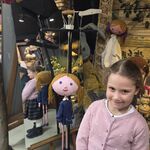 Dziewczynka pozuje przy marionetce_ w tle znajduje się lustro.
