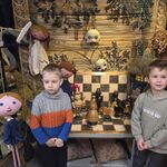 Dwóch chłopców stoi przy jednym z rekwizytów teatralnych_ szachach.