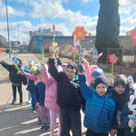 Dzieci z grupy trzeciej stoją w parach_ w dłoniach trzymają papierowe kwiatki_