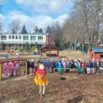 Na pierwszym planie stoi marzanna_ z tyłu_ za marzanną stoją ustawione w rzędzie dzieci z grupy trzeciej i czwartej_