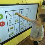 Dziewczynka rozwiązuje wiosenne sudoku na tablicy multimedialnej.