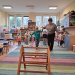 Chłopiec idzie po równoważni_ za rękę trzyma go nauczycielka_
