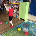 Chłopiec skacze po trójkątach sensorycznych.