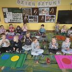 Dzieci siedzą na dywanie przed kolorowymi bibułami_ na bibułach leżą koła w odpowiednich barwach.