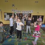 Dzieci tańczą trzymając papierowe pędzle.