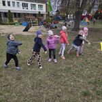 Sześcioro dzieci stoi w szeregu i puszcza jednocześnie papierowe samoloty.