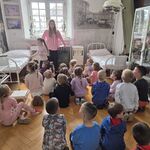 Dzieci wraz z panią przewodnik znajdują się w dawnym szpitalu wojskowym.