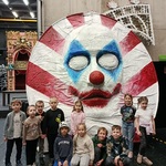 Dzieci ustawione przed duża maska_ rekwizytem 
