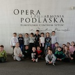 Dzieci pozują do zdjęcia pod napisem Opera i Filharmonia  Podlaska w środku 