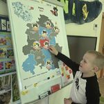 chłopiec przypina znacxek na mapie województwa podlaskiego.