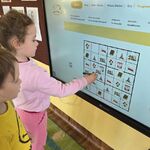 Dwoje dzieci układa sudoku na tablicy multimedialnej.