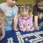 Grupa dzieci obserwuje trasę zaprogramowanego ozobota.
