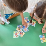 dwoje dzieci przy stoliku układa obrazki