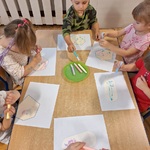 Sześcioro dzieci przy stoliku wykonuje pracę za pomocą kleju żelowego.