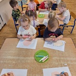 dzieci przy stolikach ozdabiają kartoniki.
