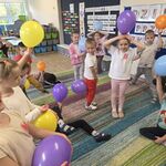 Dzieci bawią się w figurki trzymając balony.