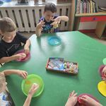 Chłopcy siedzą przy stoliku i wykonują pracę z masy solnej.