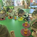 Dzieci obserwują reakcje zachodzące w uśmiechniętych kubkach.