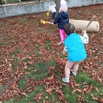 Kilkoro dzieci grabi liście.