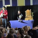 Przed dziećmi znajdują się aktorzy_ jeden trzyma pod pachą walizkę_ drugi kukiełkę królika.