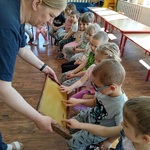 kobieta pokazuje dzieciom plaster miodu