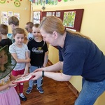 dzieci wręczają kobiecie prezent: czekoladki merci