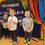 dwóch usmiechniętych małych chłopców na tle napisu pasowanie na przedszkolaka