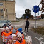 grupa dzieci w pomarańczowych kamizelkach w pobliżu ścieżki rowerowej opatrzonej znakiem drogowym