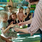 Grupka dzieci siedzi na krzesełkach i kolejno próbuje smaku soku z cytryny 5.jpg