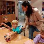 Pani przewodniczka pokazuje jak wykonać pracę plastyczną