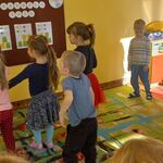 4 Dzieci stoją na dywanie i wykonują kolejne sekwencje zakodowanego tańca.jpg