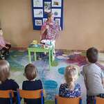 Krawcowa pokazuje dzieciom materiał do szycia ubrań