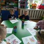 Kilkoro dzieci przy stoliku uzupełnia kartę pracy