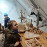 chłopiec w okularach przygląda się rzeźbom i narzędziom .jpg