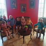 Zabytkowe meble, dzieci siedzą na fotelach i kanapie.jpg