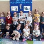 zdjęcie grupowe dzieci trzymających misie, niektóre dzieci na głowach mają papierowe opaski z misiami.