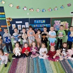 zdjęcie grupowe dzieci. Przedszkolaki siedzą i stoja trzymając misie.jpg