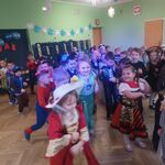 dzieci w przebraniach tańczą robiąc młynki z rąk.jpg