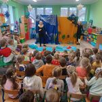 na pierwszym planie plecy widzów_ dwie panie w maskach owieczek na tle dekoracji.jpg