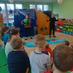 plecy widzów_ dwie panie na scenie_ jedna trzyma nadmuchany balon. W tle dekoracja wodny świat i rośliny.jpg