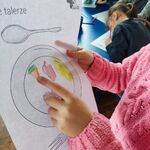 dziecko wskazuje na marchewki, które narysowało na talerzu