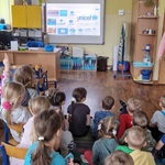 Grupa dzieci patrzy na tablicę na której wyświetlane są loga UNICEF.jpg