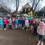 grupa dzieci ustawiona w parach_ dziewczynka trzyma w ręku kukłę marzanny