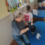 pani działkowiec nasypująca nasiona na dłoń chłopca