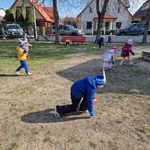 Dzieci zbierają ukryte na palcu zabaw jajeczka.