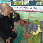 Dziewczynka próbuje reanimacji pod okiem pana strażnika.
