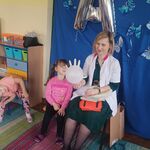 pielęgniarka z córką pokazują, jak zrobić balon z gumowej rękawiczki.