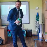 Mężczyzna w humorystyczny sposób pokazuje dzieciom kodeksy